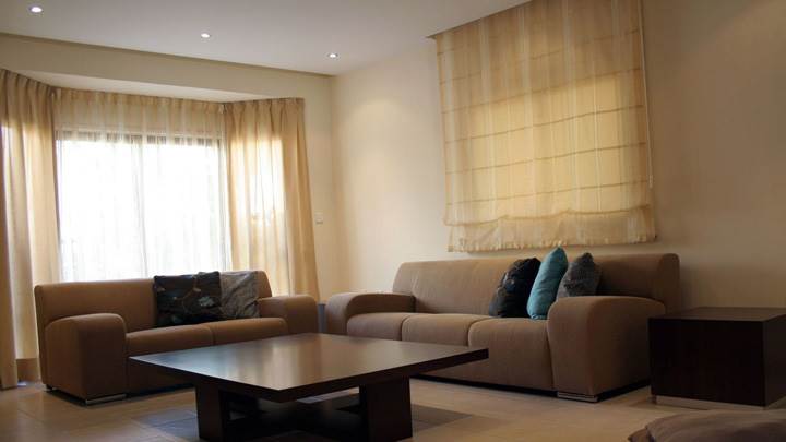 White Background And Brown Sofa Set in Guest Room